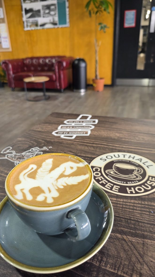 A cappuccino with latte art on a dark wood table